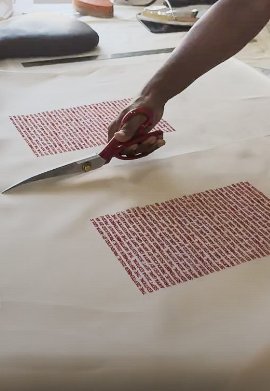 Arya Giri artisan cutting red printed panels on cotton with tailor shears 