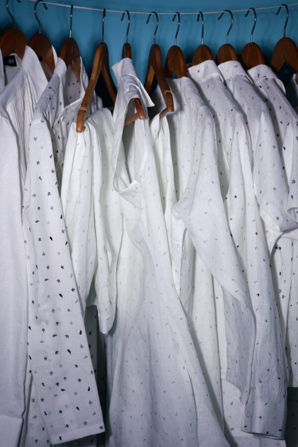 Rack of white embroidered linen shirts – Arya Giri collection of handwoven linen staples with signature detailing.